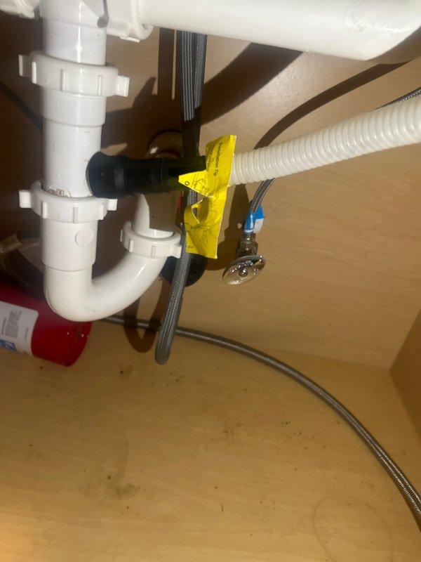 Responded to service call for dishwasher leak concern and installation verification. Upon inspection, examined under-sink plumbing connections and dishwasher drain line installation. Verified proper P-trap configuration, drain line connections, and water supply lines. Documented existing plumbing setup including PVC drain assembly, flexible discharge hose connections, and supply line installations with photographic evidence for customer records.