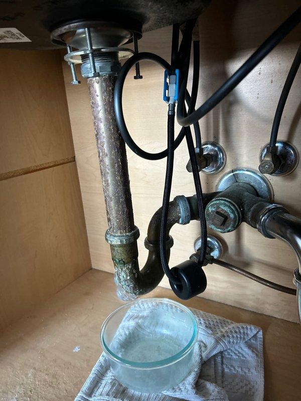 Replaced corroded chrome P-trap assembly beneath sink due to visible deterioration and green patina buildup at connection points. Installed new chrome-plated P-trap fixture to restore proper drainage function and prevent potential leaks from the compromised plumbing component.