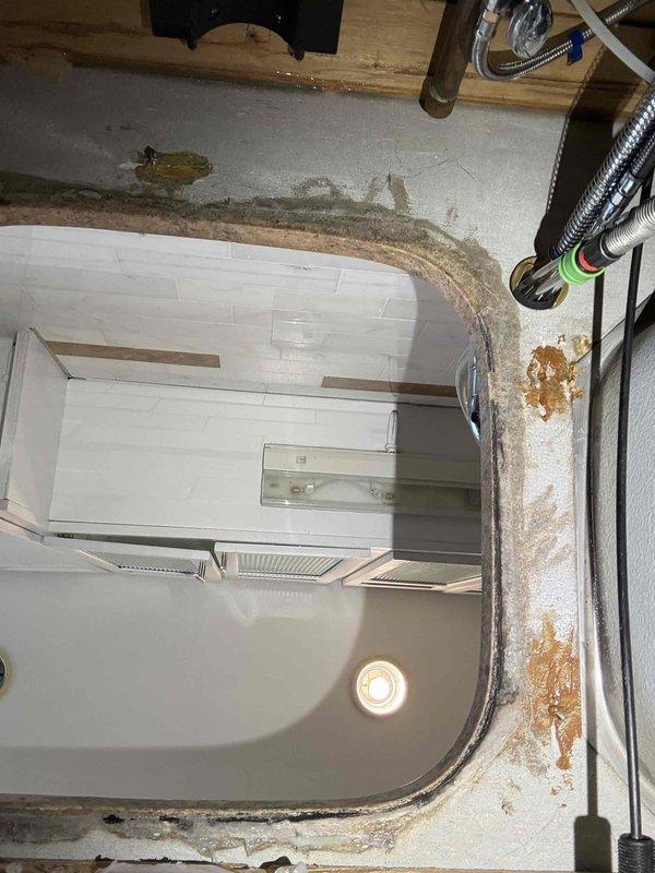 Completed installation of undermount kitchen sink with removal and replacement of deteriorated bathroom sink showing extensive water damage, mold growth, and compromised sealant around perimeter. Addressed moisture infiltration issues, replaced damaged substrate materials, and ensured proper waterproofing and drainage connections. Documented pre-existing conditions including water staining and structural deterioration for comprehensive renovation work in bathroom area.