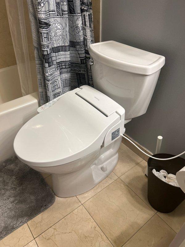 Responded to customer report of water damage in drywall below toilet, indicating potential wax ring failure. Upon inspection, removed toilet to access flange and confirmed deteriorated wax ring as source of leak. Replaced wax ring with new seal, inspected toilet flange for damage, and reinstalled toilet with proper bolting and alignment. Tested for leaks by flushing multiple times and verified no water seepage at base. Inspected visible plumbing connections including shut-off valve with blue handle and copper supply lines to ensure all connections were secure and functioning properly.