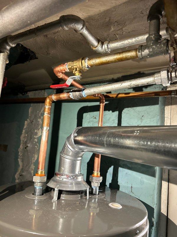 Responded to no hot water condition at residential property. Upon arrival, found recently replaced water heater with code violations related to shutoff valve and venting system. Additionally diagnosed no water flow issue to first floor following water heater replacement. Removed existing non-compliant shutoff valve and installed code-compliant valve with proper clearances and accessibility. Corrected venting configuration to meet current plumbing code requirements, ensuring proper draft and combustion air supply. Restored water service to first floor by identifying and resolving supply line obstruction in distribution piping. Verified all connections for leaks, tested water heater operation, and confirmed adequate hot water delivery throughout dwelling. System now operates safely and in full compliance with applicable plumbing codes.