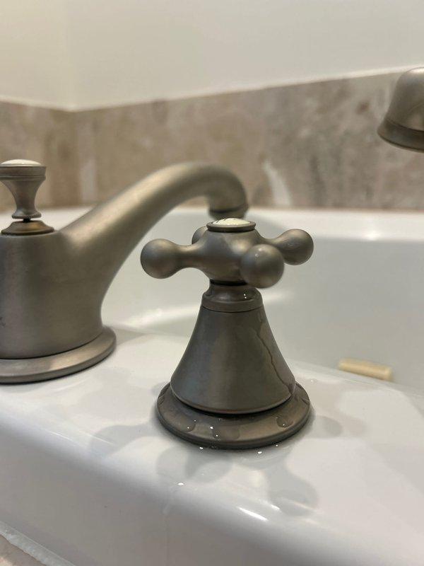 Completed installation of new bathtub and shower fixtures in master bathroom, including three cross-handle valves with brushed nickel finish, tub spout, and handheld shower head assembly mounted to tub deck. Addressed previous cold water leak on master bathroom tub by replacing faulty valve components and ensuring proper seating and seal integrity. Installed widespread bathroom sink faucet with traditional cross-handle design in brushed nickel finish, replacing previous fixture and repairing leaking kitchen sink trap with new P-trap assembly and proper compression fittings. All fixtures tested for proper operation and leak-free performance upon completion.