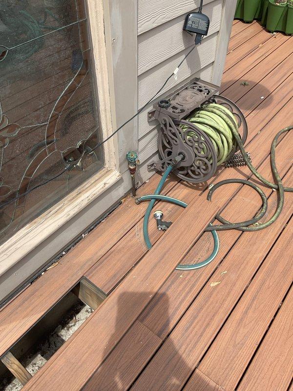 Responded to service call for slow draining bathtub and burst rooftop deck water service line. Assessed the rooftop deck plumbing system and identified failed water service line requiring complete replacement. Replaced compromised exterior water supply piping with new PVC pipe assembly, including proper fitting connections and vertical to horizontal transitions at building corner where brick wall meets siding. Addressed drainage issues in bathtub to restore proper flow. Documented existing conditions showing water damage and deterioration at pipe connection points on foundation surface prior to repairs.