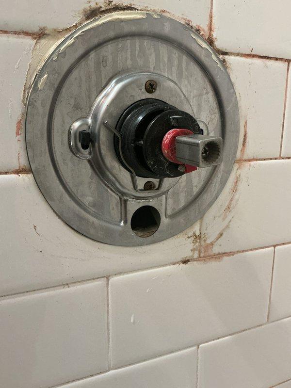 Responded to service call for leaking bathtub faucet. Upon inspection, identified worn valve stem with deteriorated rubber washer causing the leak. Disassembled the shower valve assembly, removed the damaged cartridge and seal components, and installed replacement parts. Addressed corrosion and mineral buildup around the trim plate and mounting area. Tested the repaired fixture to confirm proper operation and verified leak was eliminated.