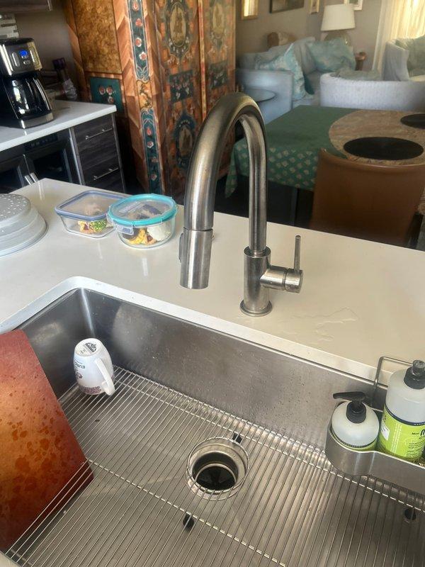 Responded to low water pressure complaint at residential kitchen sink. Upon inspection, found newly installed pull-down kitchen faucet with aerator restriction causing reduced flow. Removed and cleaned aerator screen, cleared debris buildup, and tested water pressure. Confirmed full water flow restoration with spray head functioning properly at optimal pressure. Verified undermount stainless steel sink installation and all connections secure with no leaks detected.
