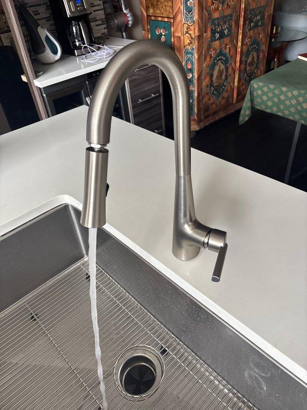 Responded to low water pressure complaint at residential kitchen sink. Upon inspection, found newly installed pull-down kitchen faucet with aerator restriction causing reduced flow. Removed and cleaned aerator screen, cleared debris buildup, and tested water pressure. Confirmed full water flow restoration with spray head functioning properly at optimal pressure. Verified undermount stainless steel sink installation and all connections secure with no leaks detected.