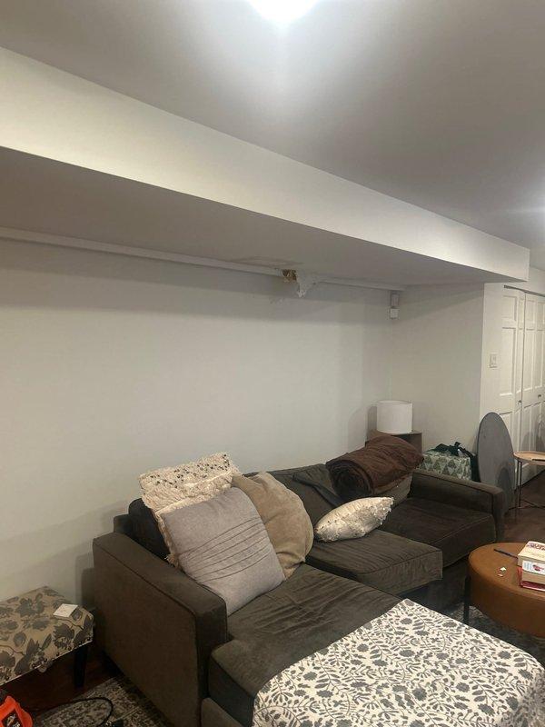 Performed water leak location service at residential property. Investigation revealed active water intrusion in main living area ceiling with visible brownish water staining and compromised drywall requiring access opening. Traced moisture source from upper level plumbing system affecting ceiling structure and identified leak origin point. Documented damage extent in both primary living space and basement level areas for repair recommendations.