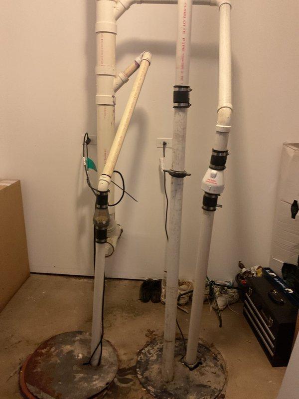 Responded to plumbing repair service call at residential property. Upon inspection, identified issues with vertical drainage system in basement utility area. Multiple PVC drain pipes showed signs of improper connections with deteriorated rubber couplings requiring replacement. Observed floor penetrations around pipe bases with significant wear and debris accumulation indicating potential water infiltration concerns. Assessed exterior foundation area where mulched landscaping adjacent to basement entrance showed settling patterns consistent with drainage issues. Replaced failing connectors with proper PVC fittings, secured all vertical drain lines, and verified proper alignment throughout the drainage stack. Cleaned floor penetrations and ensured adequate sealing to prevent future water migration. System tested and confirmed proper drainage flow with no leaks detected at connection points.