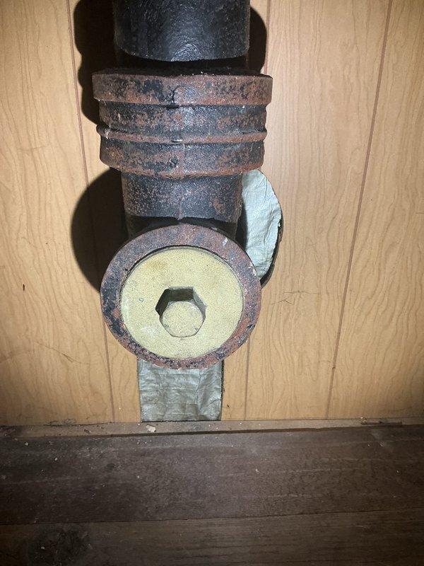Responded to service call for kitchen sink piping replacement and bathroom shut-off valve replacement. Upon inspection, discovered severely corroded plumbing fixtures with extensive rust and oxidation on pipe fittings and connections. Assessed deteriorated T-junction connector and associated threaded components showing significant moisture damage. Evaluated bathroom shut-off valve condition and provided estimate for replacement of compromised plumbing assemblies. Recommended sewer scope inspection and potential rodding service to address drainage concerns.