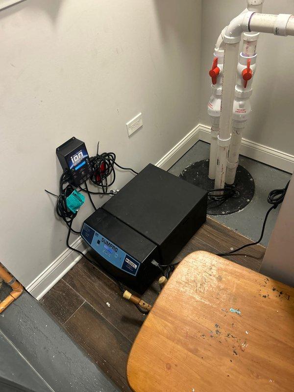 Performed routine maintenance on basement sump pump system in century-old home, including battery replacement for ION SUMPRO backup power unit. Upon inspection, existing battery was still functioning but replaced as preventive measure to ensure reliable operation during power outages. Verified system operation, tested alarm and power indicators, confirmed proper inverter function, and ensured all plumbing connections and PVC discharge piping with shutoff valves were secure and operational.