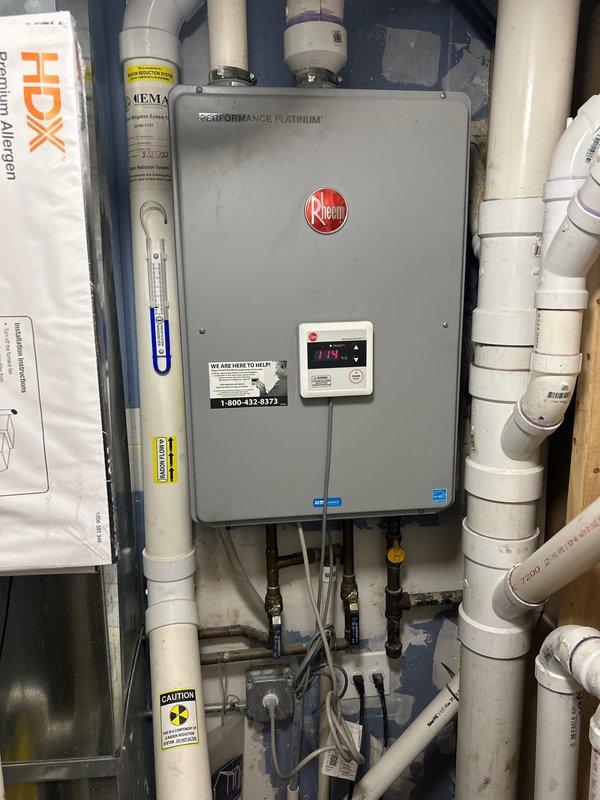 Responded to service call for newly installed Rheem Performance Platinum tankless water heater experiencing temperature limitation issues. Unit would only operate at 114°F and would not function when set to desired 120°F setpoint. Upon inspection, verified digital display showing 119°F reading and examined installation configuration including gas lines, water connections, and PVC venting system. Assessed all shut-off valves, connection points, and manufacturer specifications for proper operation parameters. Evaluated unit settings, calibration, and potential flow rate restrictions that could prevent higher temperature operation. Inspected copper supply lines with ball valves, flexible connections, and cabinet-mounted plumbing infrastructure to rule out supply-side issues affecting heater performance. Addressed temperature control functionality to restore unit to optimal operating range per manufacturer recommendations and homeowner requirements.