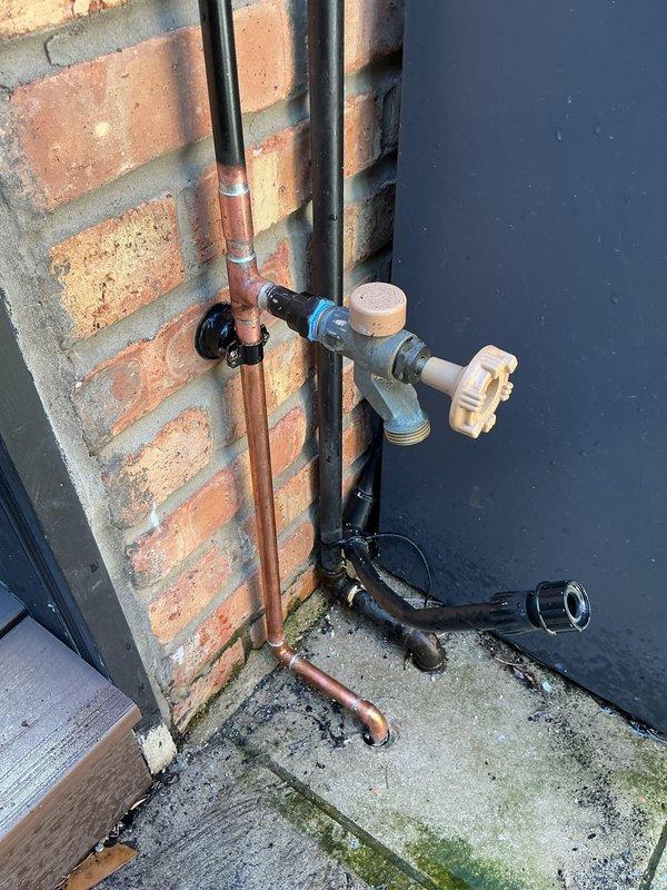 Responded to priority call for leaking outdoor spigot at 110-year-old residence. Upon inspection, found severely corroded elbow fitting on exterior hose bib with active water seepage due to age-related deterioration of original piping. Removed failed brass elbow and deteriorated sections of oxidized piping. Installed new brass compression fittings and copper pipe sections to restore proper water flow and eliminate leak. Secured all pipe runs to brick exterior wall with appropriate mounting brackets. Tested system under full pressure to verify leak elimination and proper operation of shutoff valve. All connections sealed and functioning properly upon completion.