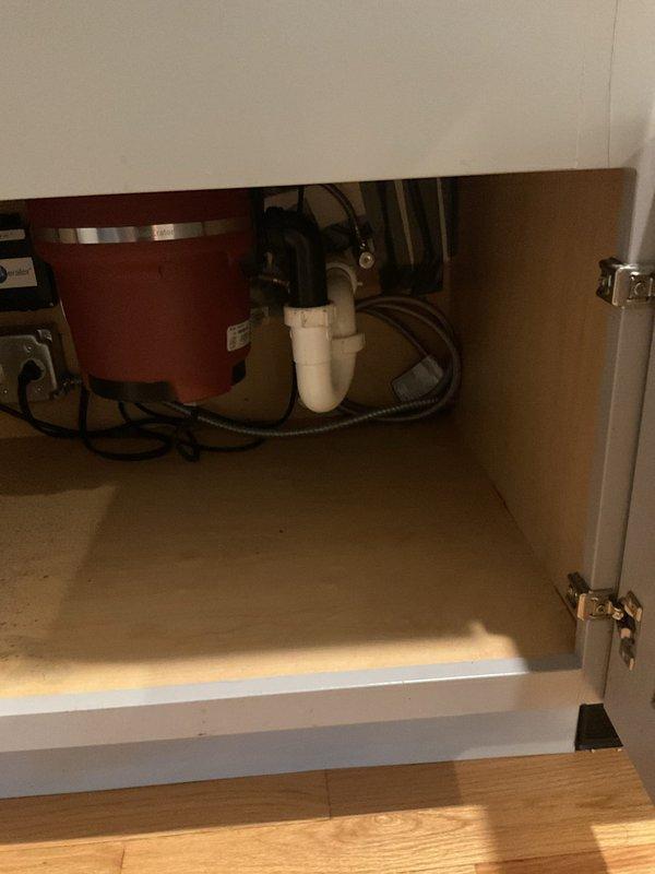 Responded to service call regarding dirty water issue at kitchen sink. Upon inspection, examined the undermount stainless steel sink, faucet assembly, and associated plumbing connections beneath the countertop. Investigated the under-sink cabinet area, inspecting the garbage disposal unit, P-trap configuration, water supply lines, and drain connections for potential sources of contamination or sediment causing discolored water at the fixture. Documented existing plumbing conditions with photographic evidence for estimate purposes.