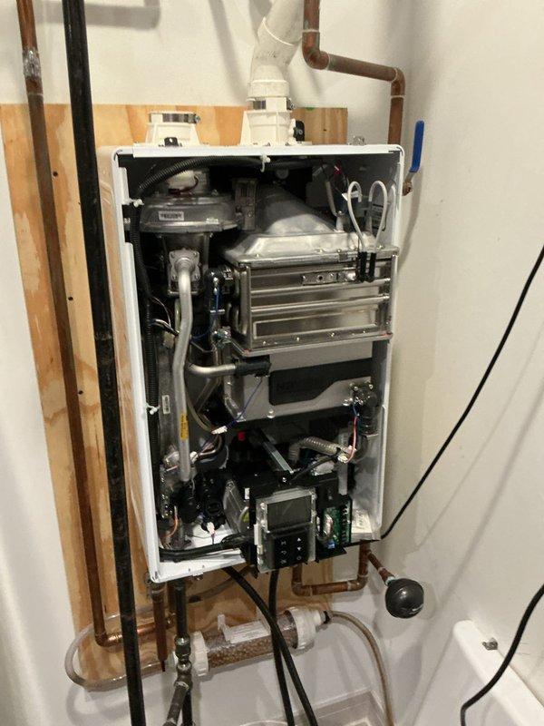 Completed VIP plumbing maintenance inspection at residential property. Performed comprehensive assessment of tankless water heater system, removing front access panel to inspect internal components including heat exchanger plates, gas burner assembly, electronic control board, and water flow sensors. Verified proper operation of copper supply lines, pressure relief valves, and shut-off valves. Inspected bathroom ventilation system, confirming proper mounting and functionality of ceiling-mounted exhaust fan with mesh filter screen. All systems found to be operating within normal parameters with no immediate service needs identified.