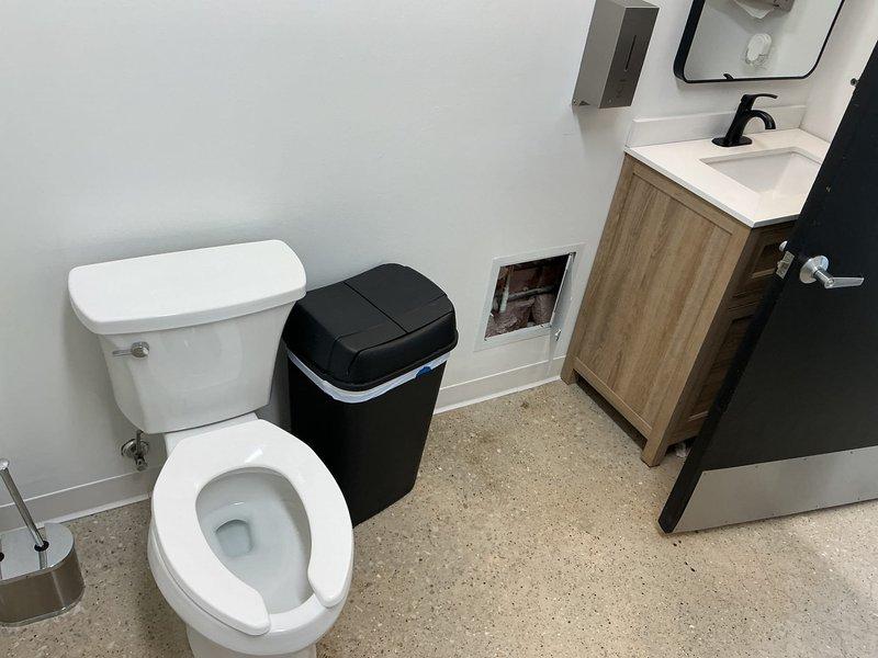 Upon video inspection of the sewer from the rear cleanout, identified a pitch issue with the rear bathroom sewer causing water and sewerage to form soft blockages over time. The toilet and lavatory sink in the rear bathroom share a double wye fitting that is slightly backpitched, causing water and waste to flow backward before flowing forward down the sewer, resulting in waste accumulation over time. Also discovered a hole in the riser for the 4" floor drain in the rear bathroom. The front bathroom connection to the main sewer is positioned very close to the problematic double wye fitting.

Performed complete sewer line repair by separating the lavatory drain and toilet drain, giving each their own wye fitting connecting to the main sewer. Saw cut and broke up concrete in the rear bathroom to excavate and expose the backpitched 4" cast iron double wye fitting and section of 4" cast iron main sewer behind the floor drain connection. Removed toilet in the front bathroom and opened the wa