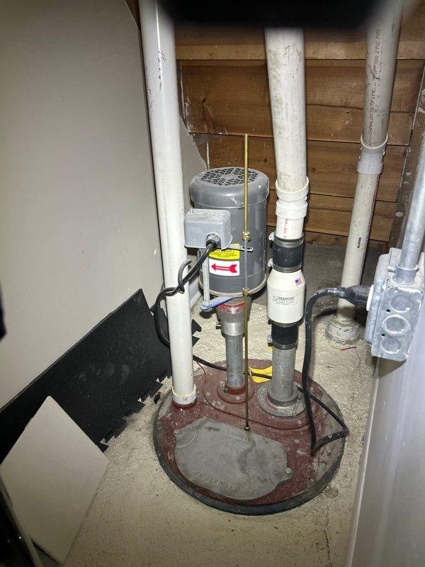 Completed standard plumbing maintenance inspection with no reported concerns. Inspected sump pump system in basement, confirming proper operation of pump motor, basin, and discharge piping. Verified all PVC connections, rubber couplings, and electrical wiring were secure and functioning correctly. Examined brass P-trap assembly and drain system beneath sink fixture, confirming proper drainage and no signs of leaks or deterioration. All plumbing components found to be in good working order with no immediate repairs required.
