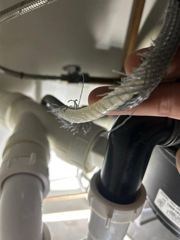 Responded to intermittent leak detection under kitchen sink. Upon inspection, identified compromised connection on braided flexible supply line feeding the reverse osmosis filtration system. Tightened supply line fitting and verified all connections to the RO tank, disposal unit, and P-trap assembly for proper seal integrity. Cabinet liner showed evidence of previous water accumulation, confirming intermittent leak pattern. All plumbing components tested and secured; no active leaks detected upon completion.