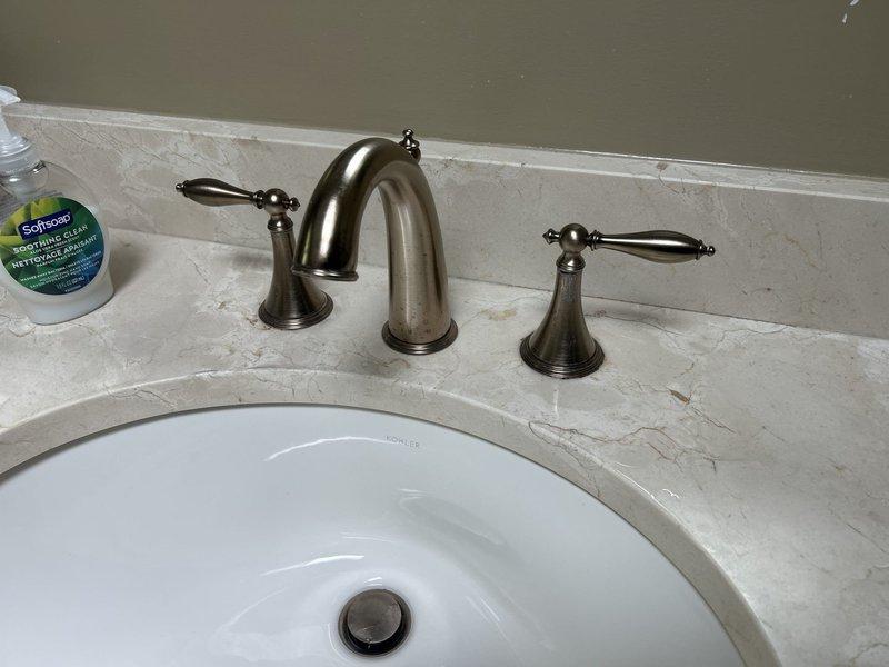 I notice there's a significant discrepancy between the service type listed (Plumbing Install - Outdoor Spigot/Shower) and the photographic evidence provided, which shows interior bathroom fixtures including a vanity sink with faucet installation and a toilet. 

Based on the actual work documented in the photographs: Completed installation of bathroom plumbing fixtures including a white undermount porcelain sink with widespread three-piece faucet assembly in brushed nickel finish, mounted to stone countertop. All fixtures tested for proper operation and verified leak-free connections.