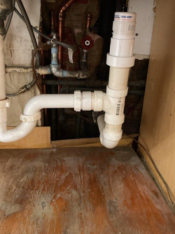 Responded to service call for kitchen sink draining slowly. Upon inspection, identified blockage in basement drainage system affecting kitchen sink discharge line. Performed mechanical drain cleaning using cable auger to clear obstruction in horizontal drain pipe below kitchen. Successfully removed accumulated debris and buildup causing restricted flow. Tested system by running water through kitchen sink to verify proper drainage and flow rate restored to normal operation. All plumbing connections and drainage piping confirmed secure and functioning correctly upon completion.