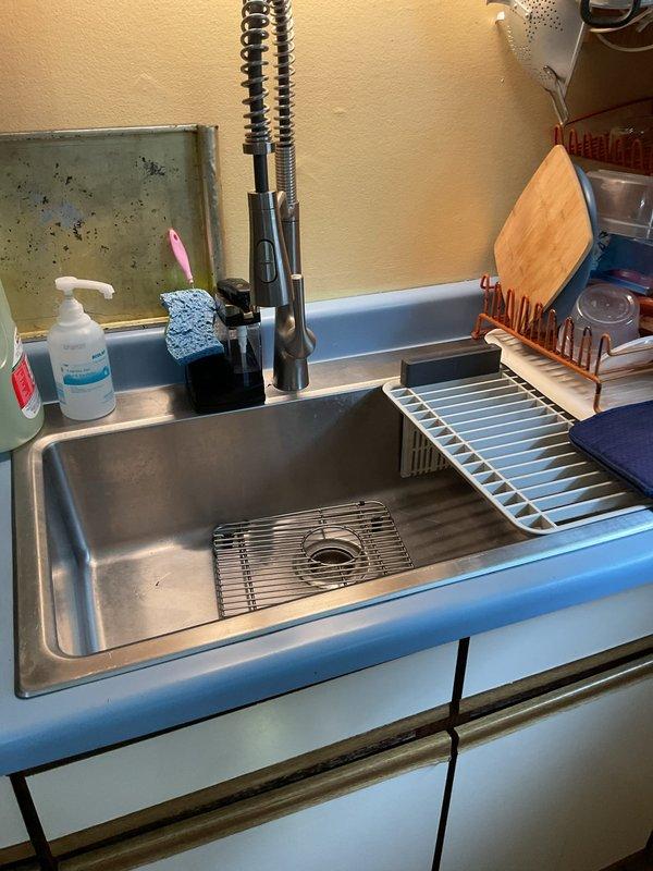 Responded to service call for kitchen sink draining slowly. Upon inspection, identified blockage in basement drainage system affecting kitchen sink discharge line. Performed mechanical drain cleaning using cable auger to clear obstruction in horizontal drain pipe below kitchen. Successfully removed accumulated debris and buildup causing restricted flow. Tested system by running water through kitchen sink to verify proper drainage and flow rate restored to normal operation. All plumbing connections and drainage piping confirmed secure and functioning correctly upon completion.