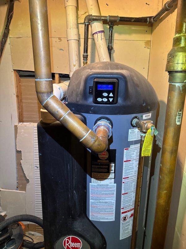 Responded to service call for Rheem Commercial RUUD tanked water heater displaying error code with no hot water production. Upon arrival, diagnosed the unit through digital control panel interface and visual inspection of all components. Evaluated copper supply and discharge piping connections, exhaust venting system, and electrical connections to the control board. Cleared error code from system, verified proper temperature settings on LCD display panel, and tested unit operation to confirm restoration of hot water service. All plumbing connections, gas lines, and safety devices inspected and confirmed to be functioning within manufacturer specifications.
