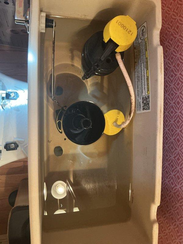 Responded to service call for toilet with broken seat and continuous running water. Upon inspection, removed tank lid and identified worn flapper valve and flush valve assembly requiring replacement. Installed new Kohler flapper valve and flush valve components, securing with manufacturer-specified hardware. Replaced damaged toilet seat with new unit, fastening securely with appropriate mounting brackets. Tested flush mechanism for proper operation, verified water shutoff functionality, and confirmed no leaks present. All components functioning correctly upon completion.