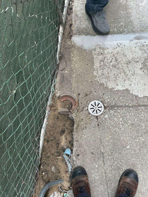 Conducted site assessment for exterior drainage system installation to address water pooling issues along sidewalk adjacent to residential structure. Evaluated existing concrete pathway conditions, identified optimal drain placement location, and assessed proximity to existing drainage infrastructure including nearby catch basin for tie-in connection. Documented current site conditions including weathered concrete surfaces, existing floor drain, and areas of water accumulation near fence line and building foundation. Provided estimate for installation of new exterior drain system with connection to existing drainage lines to mitigate heavy rainfall pooling concerns.