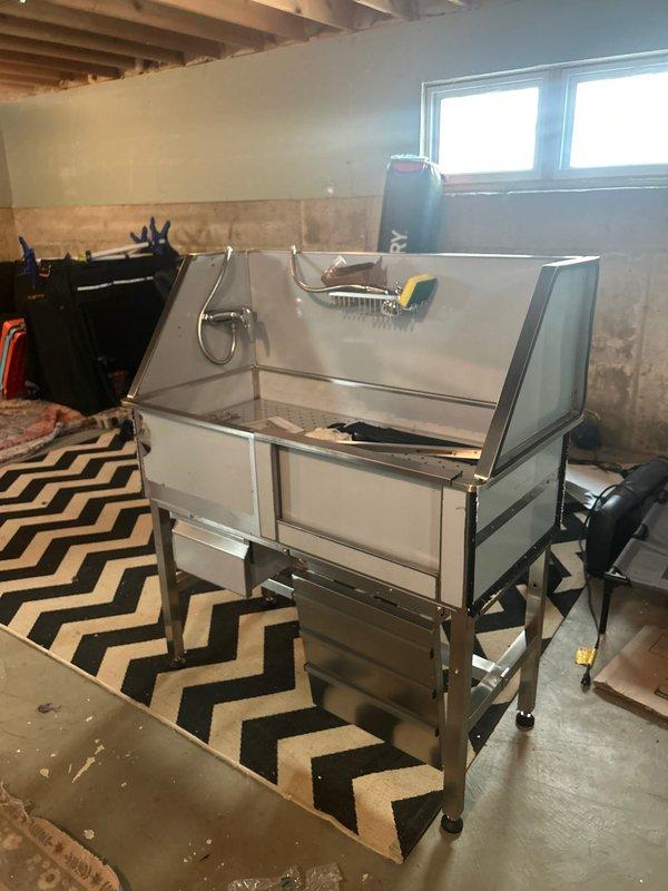 Removed and replaced existing utility sink in basement with new stainless steel dog washing station. Connected all necessary plumbing lines including hot and cold water supply using copper and PVC piping, ensuring proper drainage and secure fittings with appropriate clamps and connections. Unit was installed on casters for mobility, tested for leaks, and confirmed fully operational upon completion.