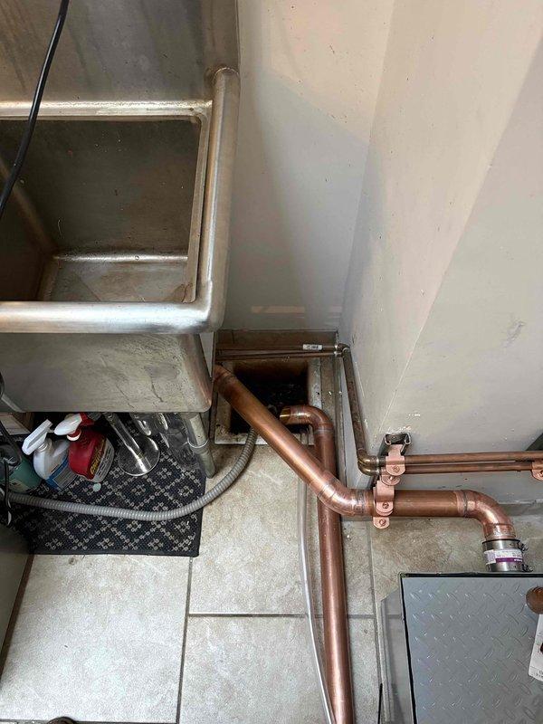Initiated installation of commercial water boiler and hand sink in commercial kitchen facility. Completed rough-in plumbing connections including copper piping installation and routing for both water heater system and hand washing station. Installation remains incomplete pending acquisition of specialized faucet components from supplier, with return visit scheduled to complete fixture mounting and final connections for both the commercial boiler unit and hand sink assembly.