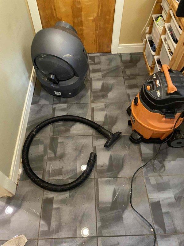 Responded to water intrusion emergency in residential hallway. Deployed wet/dry vacuum and extraction equipment to remove standing water from tile flooring. Assessed sump pump system failure that resulted in basement flooding and water migration to main floor corridor. Utilized commercial-grade water extraction tools and hoses to eliminate pooled water and begin drying process to prevent secondary damage to flooring and baseboards.
