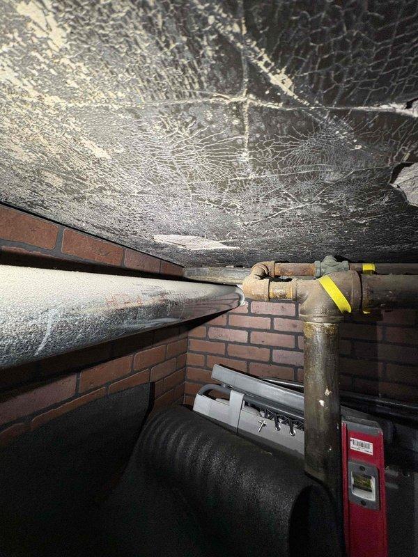 Responded to emergency gas leak call with gas supply still active. Upon arrival, accessed crawlspace utility area and located gas distribution system with brass shutoff valve and control assembly. Performed comprehensive visual inspection of gas piping infrastructure, identifying leak source in aging gas line system. Documented existing conditions including deteriorated ceiling materials and compromised insulation in mechanical space. Conducted pressure test on gas system to verify leak location and assess integrity of connected piping. Tagged affected gas lines for repair and provided detailed photographic documentation of leak area and surrounding mechanical infrastructure for estimate preparation.
