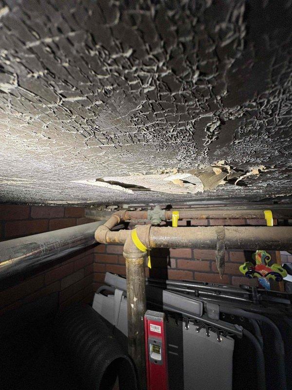 Responded to emergency gas leak call with gas supply still active. Upon arrival, accessed crawlspace utility area and located gas distribution system with brass shutoff valve and control assembly. Performed comprehensive visual inspection of gas piping infrastructure, identifying leak source in aging gas line system. Documented existing conditions including deteriorated ceiling materials and compromised insulation in mechanical space. Conducted pressure test on gas system to verify leak location and assess integrity of connected piping. Tagged affected gas lines for repair and provided detailed photographic documentation of leak area and surrounding mechanical infrastructure for estimate preparation.