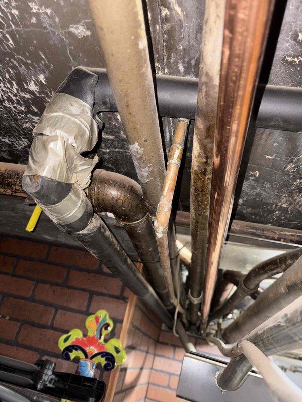 Conducted comprehensive site assessment for 2-inch gas line re-piping project in basement utility area. Evaluated existing piping infrastructure, which included aging copper lines showing significant corrosion and patina, black PVC pipes, and various diameter gas lines with makeshift repairs including tape-wrapped connections. Documented current condition of mechanical systems, noting deteriorated metal couplings with heavy rust oxidation, compromised pipe joints, and overall aging infrastructure requiring replacement. Photographed existing piping layout running vertically and diagonally through confined utility space, including proximity to HVAC equipment and structural elements. Assessed scope of work needed to remove and replace existing gas piping system with new 2-inch gas line installation, accounting for complex routing requirements and integration with existing mechanical systems. Provided detailed visual documentation and measurements for accurate pricing estimate.