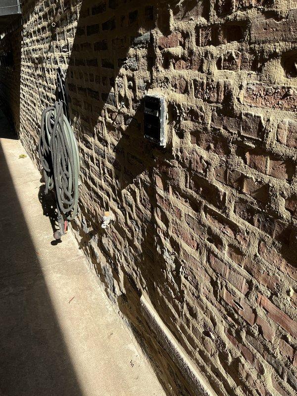 Responded to emergency service call for broken outdoor spigot handle mounted on deteriorated brick exterior wall. Removed damaged faucet fixture that had been mortared into brick masonry, requiring careful drilling to extract without causing further structural damage to the already compromised wall surface. Installed new outdoor spigot with proper mounting hardware and sealed penetration point to prevent water intrusion behind brick veneer.
