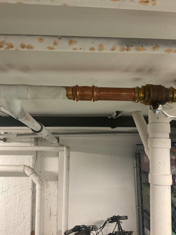 Completed installation of new plumbing piping system in basement utility area, including copper supply lines with brass fittings and white PVC drainage piping with multiple directional changes, elbows, and T-joints. Work was performed during a scheduled building shutdown to minimize disruption. All piping was properly secured to ceiling joists with appropriate mounting brackets and clips, ensuring code-compliant installation and optimal drainage flow.