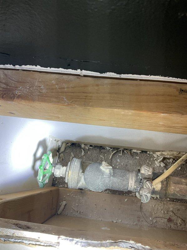 Responded to customer concern regarding inadequate hot water supply to a single shower fixture while all other plumbing fixtures in the home received proper hot water temperature. The 50-gallon tank-style water heater was functioning correctly and providing adequate hot water to the distribution system. Upon inspection of the affected shower, accessed the plumbing assembly through the floor access point and identified a partially closed shut-off valve with green cross-handle control. Opened the valve to full position to restore proper hot water flow to the shower fixture, resolving the isolated temperature issue.