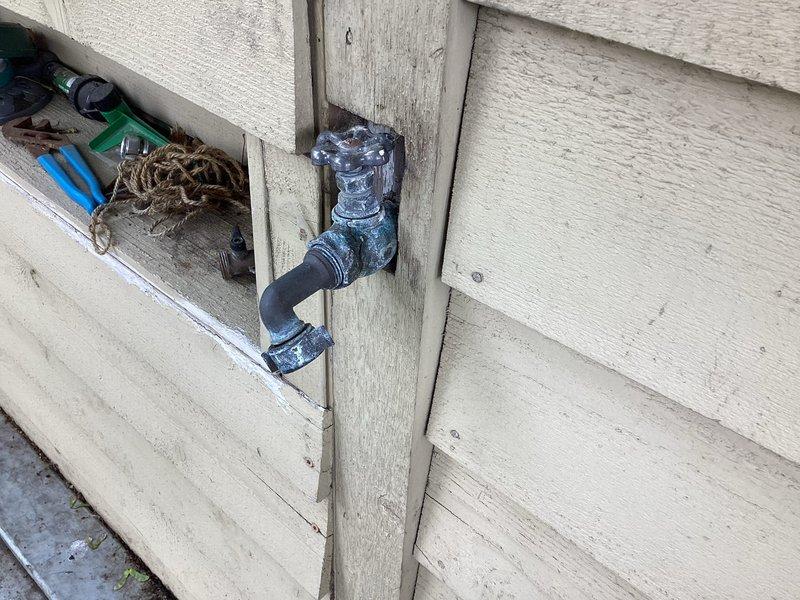 Replaced outdoor faucet assembly on exterior wall, installing new frost-free sillcock with shutoff valve and connecting to existing supply line. Removed old weathered fixture, secured new brass fitting to vertical trim post, and verified proper operation with no leaks detected upon testing.