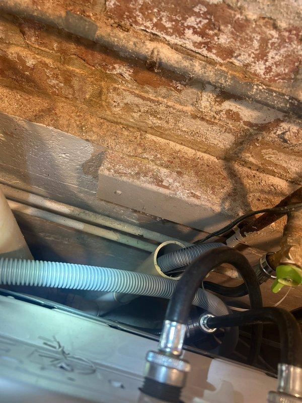 Responded to plumbing service call for leaking PVC pipe underneath washer and leaking outdoor spigot. Inspected exterior hose bib mounted on brick wall and identified leak at valve body connection. Assessed interior plumbing system in crawl space where PVC supply line showed active leak beneath washing machine location. Repaired both leaking fixtures to restore proper water flow and eliminate water damage concerns.