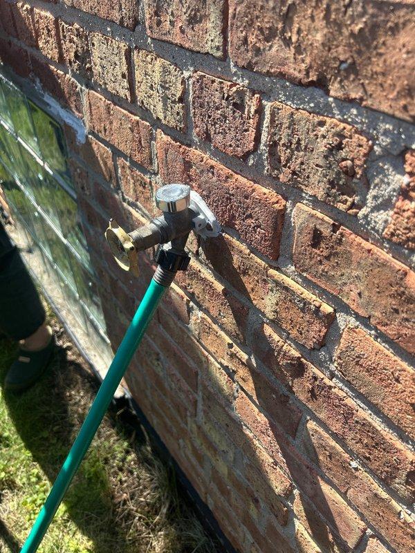 Responded to plumbing service call for leaking PVC pipe underneath washer and leaking outdoor spigot. Inspected exterior hose bib mounted on brick wall and identified leak at valve body connection. Assessed interior plumbing system in crawl space where PVC supply line showed active leak beneath washing machine location. Repaired both leaking fixtures to restore proper water flow and eliminate water damage concerns.