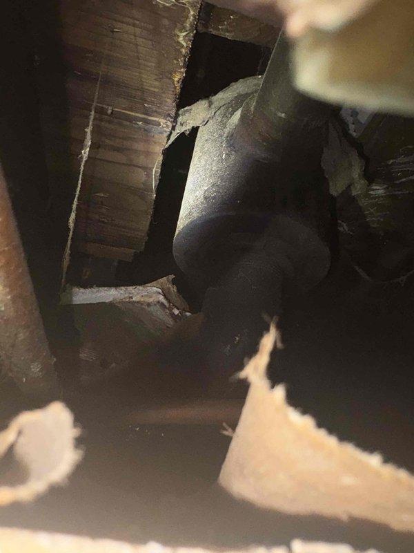 Completed plumbing piping installation in crawlspace area, routing new ductwork and piping through structural framing with proper insulation wrapping. Integrated new copper piping with existing galvanized pipe system using 90-degree elbow joints, ensuring proper connections to aged infrastructure while maintaining structural integrity throughout the installation.