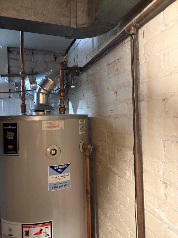 Responded to no hot water complaint at residential property with 70-year-old infrastructure and tank-style water heater. Upon arrival, conducted comprehensive diagnostic assessment of the water heating system. Inspected the white cylindrical tank water heater located in basement utility area, examining all visible components including copper supply lines, pressure relief valve, temperature controls, and venting system.

Evaluated the metallic exhaust vent connector at top of unit for proper draft and combustion air flow. Tested electrical connections and thermostat functionality to determine root cause of complete hot water loss throughout home. Examined the condition of copper piping infrastructure, brass fittings, and shut-off valves for any signs of leaks, corrosion, or mechanical failure.

Checked pilot light assembly and burner operation on gas-fired unit. Verified proper gas supply and pressure to appliance. Inspected flue pipe connections and draft diverter for blockages or impr
