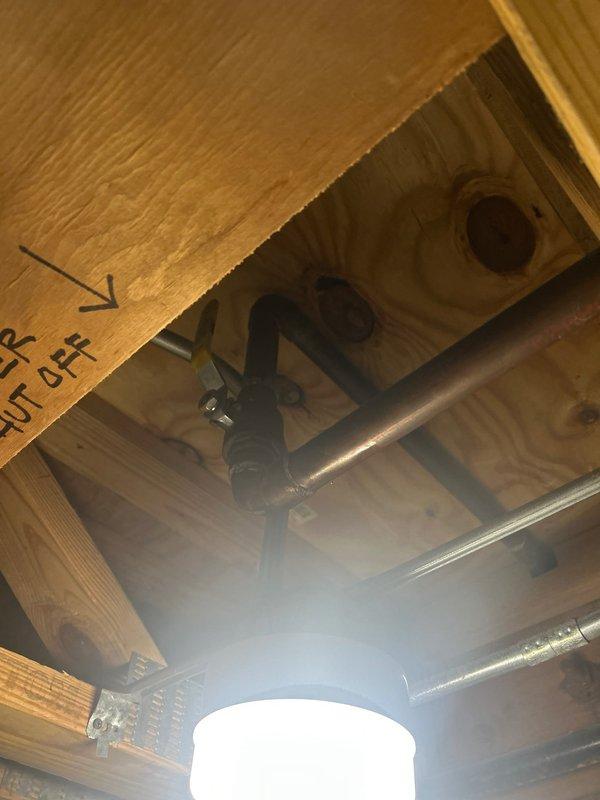 Completed water heater installation in basement utility area with proper shut-off valve configuration and supply line connections. Verified attic plumbing shutoff valve location and marked access point for future maintenance reference.
