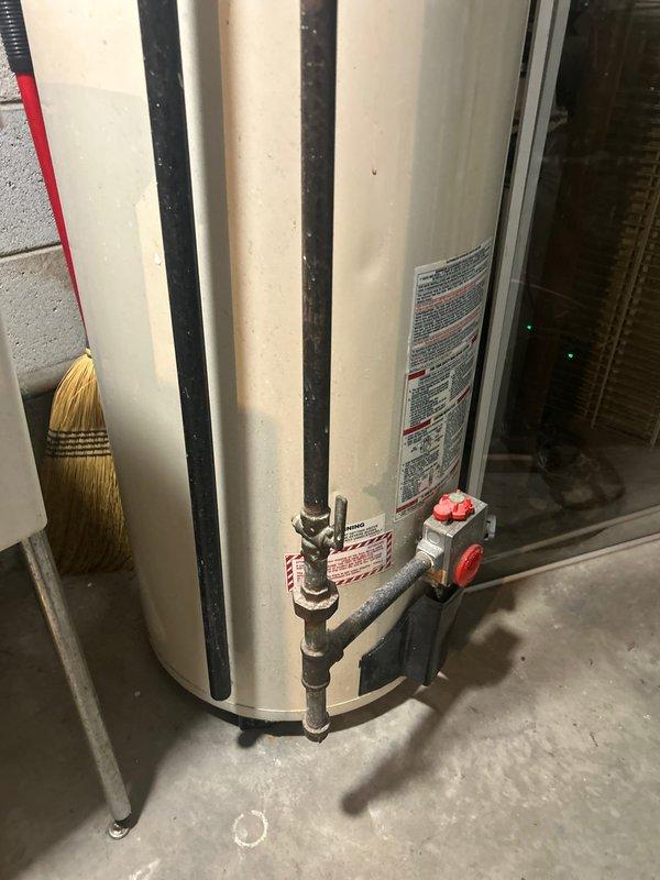 Completed water heater installation in basement utility area with proper shut-off valve configuration and supply line connections. Verified attic plumbing shutoff valve location and marked access point for future maintenance reference.