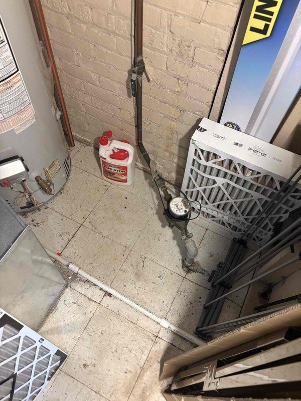 Completed installation of residential tanked water heater in utility room with existing plumbing infrastructure. Unit features gas-fired operation with standard safety controls, brass pipe connections, and bottom-mounted control panel. Connected copper supply lines to existing plumbing system and verified all connections for proper operation and leak-free performance.