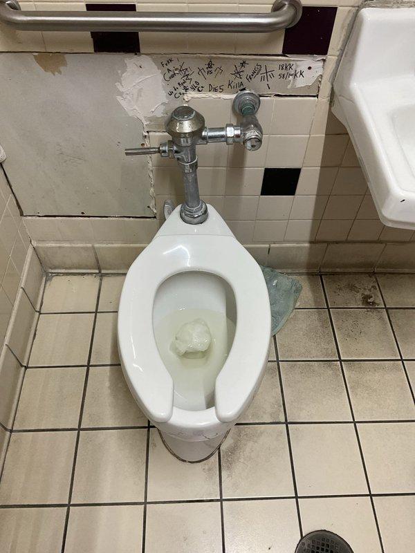 Responded to service call for malfunctioning Sloan flush valve toilet in commercial restroom facility. Upon inspection, found aging wall-mounted flush valve mechanism with deteriorated internal components causing improper flushing operation. Assessed overall condition of toilet fixture and flush valve assembly. Documented existing bathroom conditions including worn tile surfaces and aging plumbing fixtures. Provided evaluation and recommendations for toilet servicing or replacement options to restore proper functionality to the flush system.