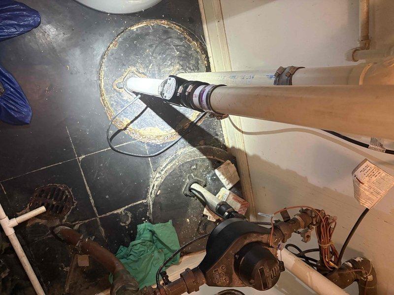 Responded to service call for noisy sump pump that was operational but unplugged due to excessive noise during operation. Upon inspection, found dual sump pump installation with visible signs of deterioration including rust staining, mineral deposits, and corrosion around floor-mounted bases and discharge piping connections. Documented existing conditions showing worn rubber couplings, corroded metal bases, and mineral buildup on both pump installations. Assessed pump performance and mechanical components to determine source of abnormal noise levels. Provided diagnostic evaluation and photographic documentation of equipment condition for repair estimate consideration.
