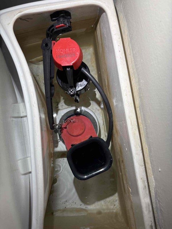 Responded to service call for toilet with slow drainage and flushing issues. Upon inspection, found existing Kohler flush valve assembly with flapper mechanism that had been previously replaced by customer without resolving the problem. Tested flush cycle and confirmed toilet bowl drains slowly, indicating partial blockage in trap or drain line rather than tank component failure. Documented tank interior components and water flow patterns for diagnostic purposes. Advised that issue stems from drainage obstruction, not flush mechanism, and recommended drain clearing or possible toilet removal for trap inspection to restore proper flow and drainage speed.