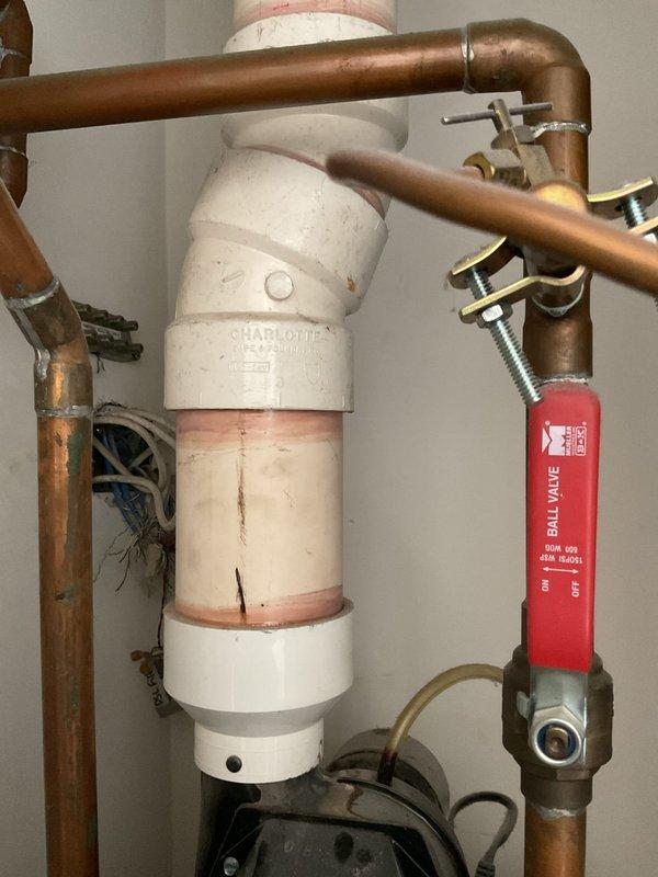Responded to no hot water complaint and performed comprehensive inspection of Rheem PowerVent tanked water heater installation. Documented existing plumbing configuration including copper supply lines, ball valve shut-off assembly, PVC venting components, and integrated pump system. Photographed complete installation showing water heater positioned in utility closet alongside HVAC equipment, with visible pressure relief valve, multiple connection points, and proper venting arrangement to assess system condition and identify cause of hot water failure.