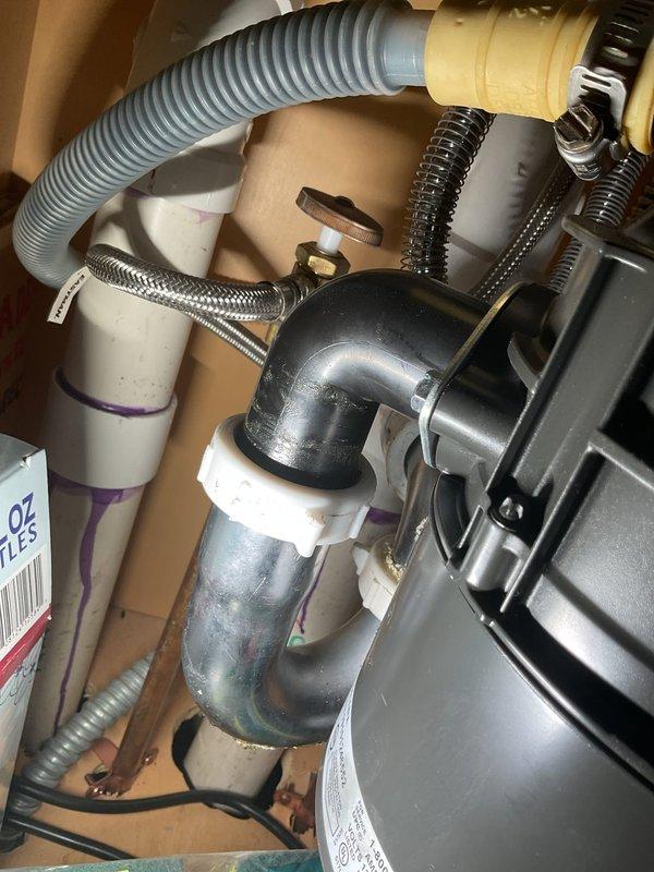 Responded to service call for multiple plumbing issues including backed-up garbage disposal, continuously running toilet, and audible dripping in sump pump piping. Inspected toilet mechanism and identified fill valve malfunction causing phantom flushing. Examined sump pump system and diagnosed compromised discharge line connection causing water hammer and dripping sounds within piping. Documented existing plumbing conditions with photos showing toilet assembly with supply line and sump pump components including discharge piping, flexible hoses, and pump unit housed in basin. Provided recommendations for repairs including toilet fill valve replacement, garbage disposal drain line clearing, and sump pump discharge line repair to eliminate water intrusion and restore proper system operation.