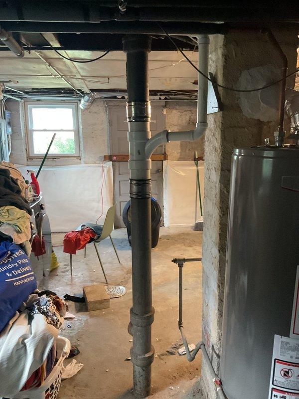 Responded to service call for water leaking from bathtub spout when toilet is flushed. Inspected bathroom plumbing fixtures including vintage-style tub faucet with cross-handle controls and handheld shower attachment. Examined basement plumbing system with exposed piping and drain lines to identify cross-connection or venting issue causing water to discharge through tub spout during toilet flush cycle. Documented existing plumbing configuration and fixture conditions. Provided estimate for necessary repairs to resolve improper drainage and prevent continued water diversion through bathtub spout.